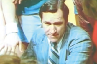 Coach Smith crouches in the middle of huddle during a timeout in the 1974 UNC/Duke basketball game.