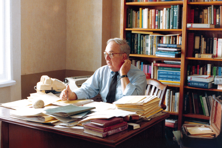 A photo of Edward F. Callahan sitting at his desk in his office.