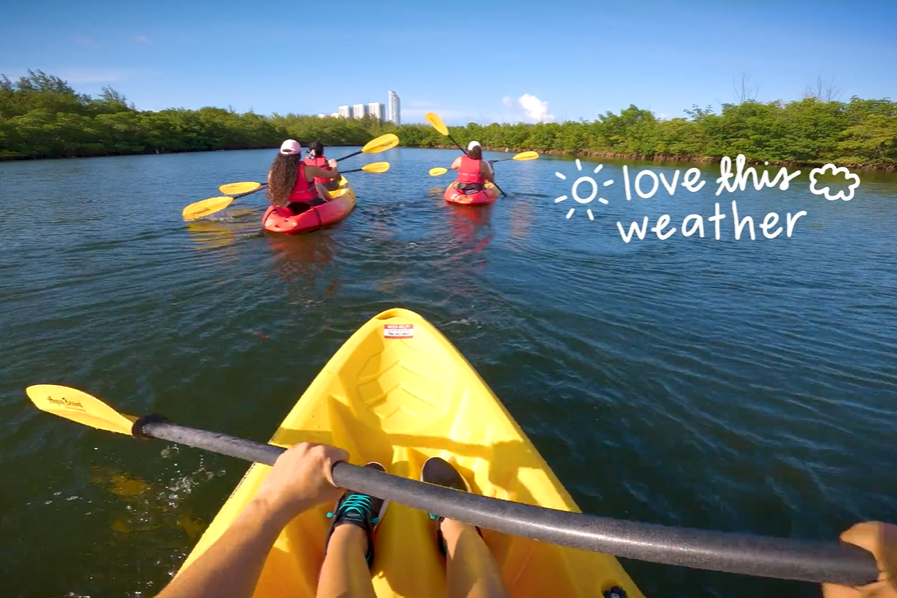 A screenshot of FIU recruitment video shows a point-of-view shot of a student kayaking.