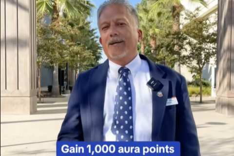 A screenshot from Fullerton's Gen Z TikTok video. A Fullerton staff member stands on campus and the caption reads "Gain 1,000 aura points."