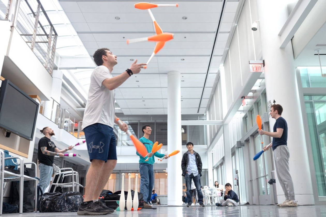 The Cornell Juggling Club practices in the atrium of a campus building.