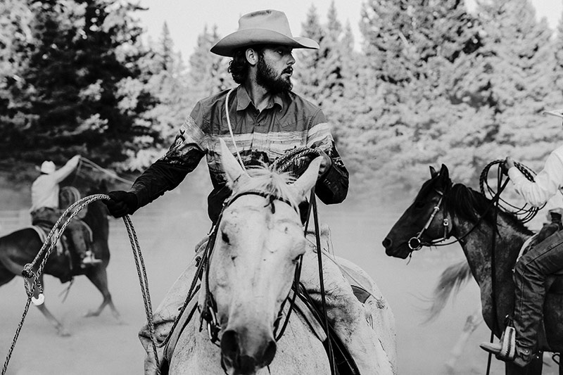 Photograph of Tristen Ellison riding a horse, rope in hand.