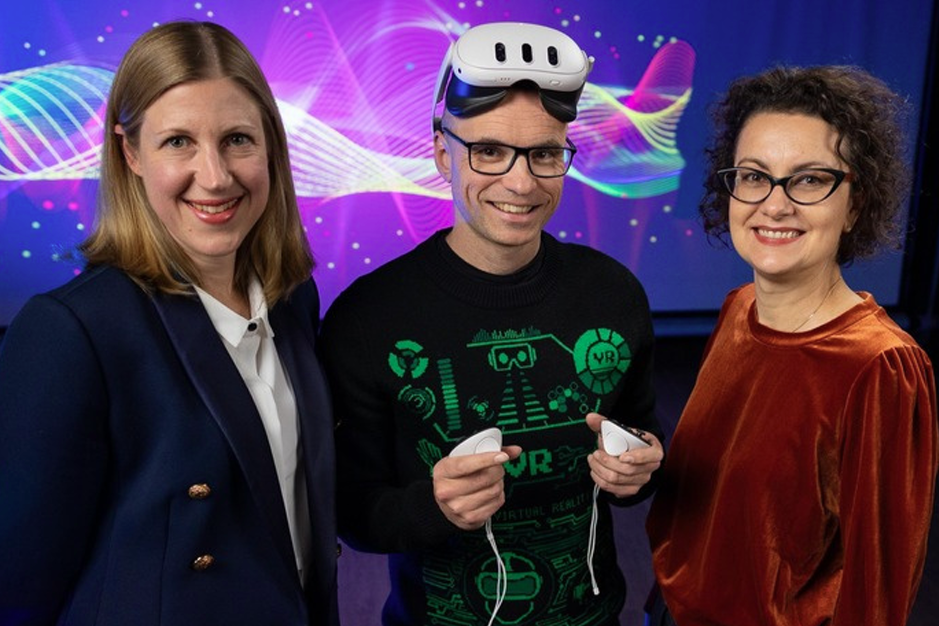 From left to right, Solange Glasser, Ben Loveridge (wearing an VR-set), and Margaret Osborne pose for a photo.