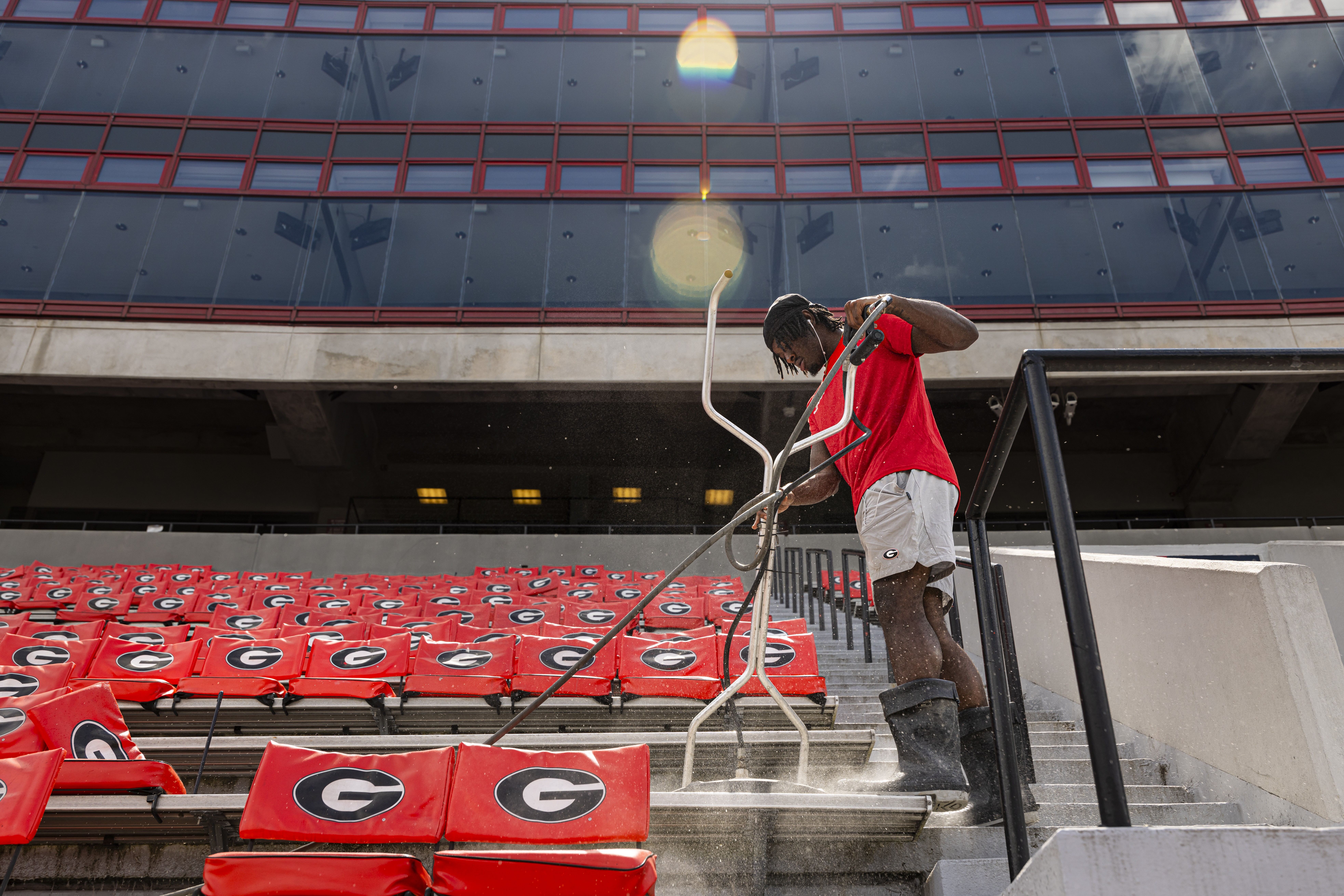 A man power washes the stands in the University of Georgia's football stadium.