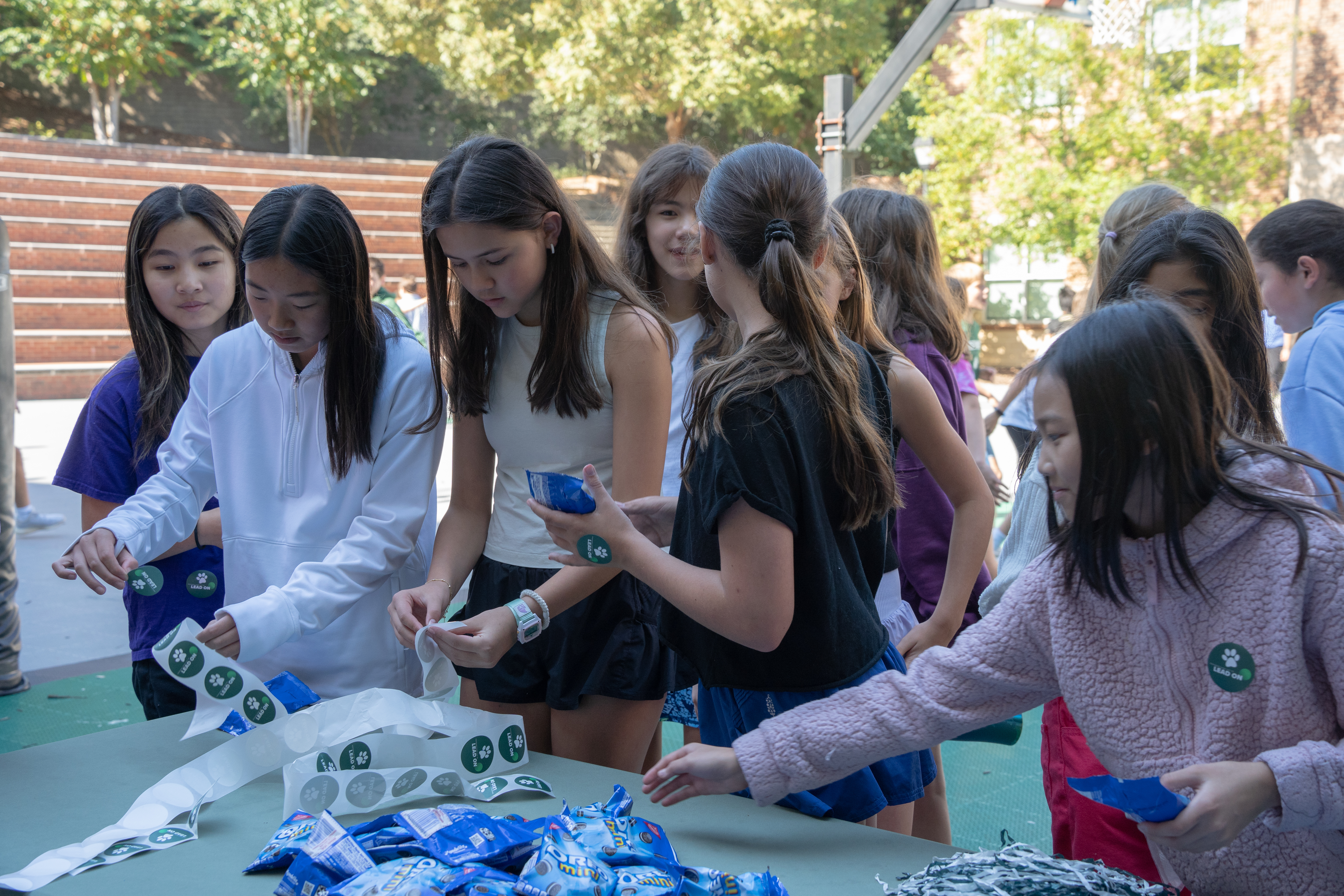 Students from The Westminster Schools crowd around a table to get stickers and Oreos.