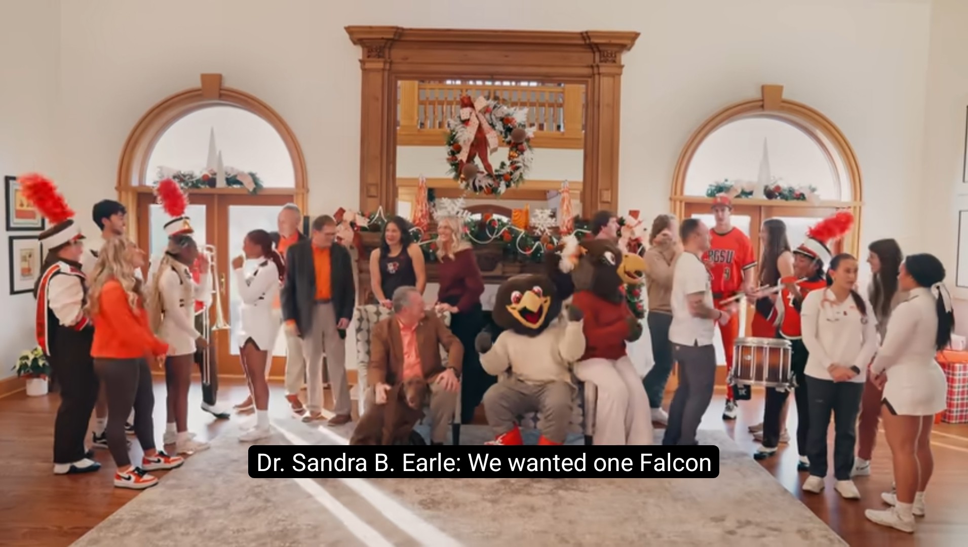 Members of BGSU's marching band, sports teams, and more gather with the university's mascots and president for a holiday photo.