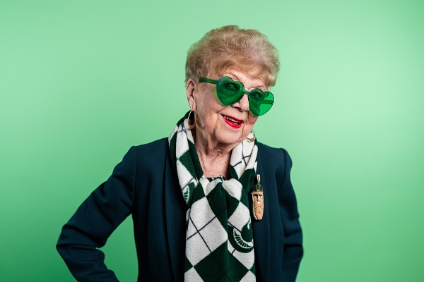 A photo of Jan Alleman wearing green heart-shaped sunglasses.