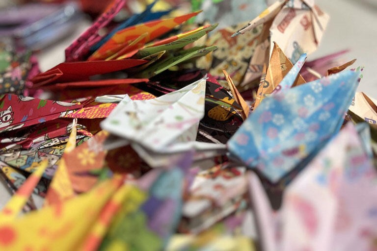A pile of origami cranes, all made from different patterned paper.