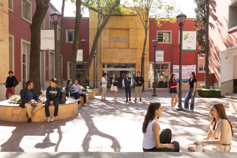 A photo of the ITAM campus. Students and professors spend time in a shaded courtyard.