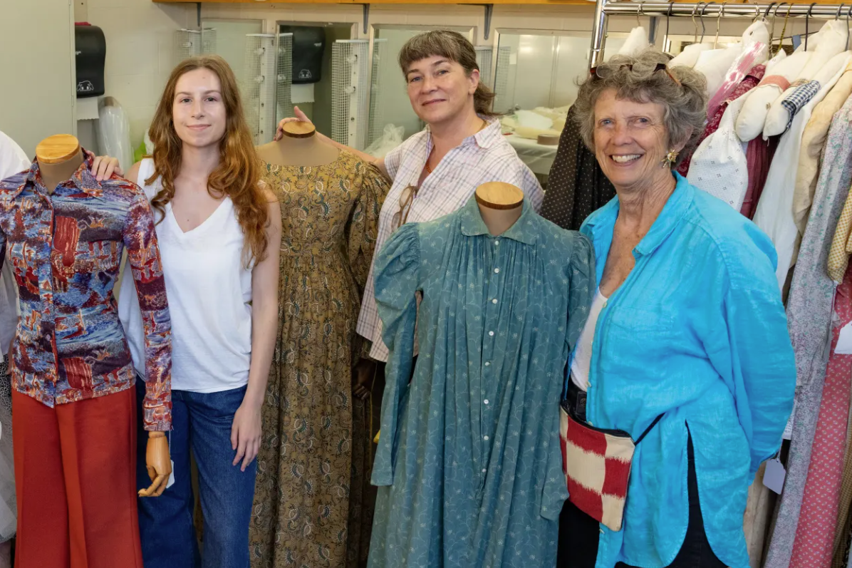 Virginia Cornett ’27, Rebecca Shea ’99, and Kiki Smith ’71, pose amongst busts dressed in women's clothes from Smith College's Historic Clothing Collection. 