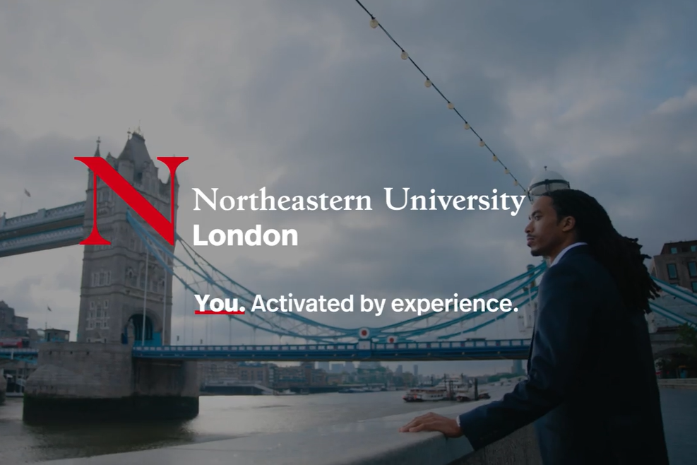 A man stands beside the Thames River, Tower Bridge in the background, with the words, "Northeastern University London: You. Activated by experience."