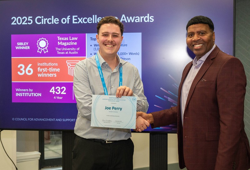 Joe Perry, award winner, shaking the hand of CASE VP, Rob Henry