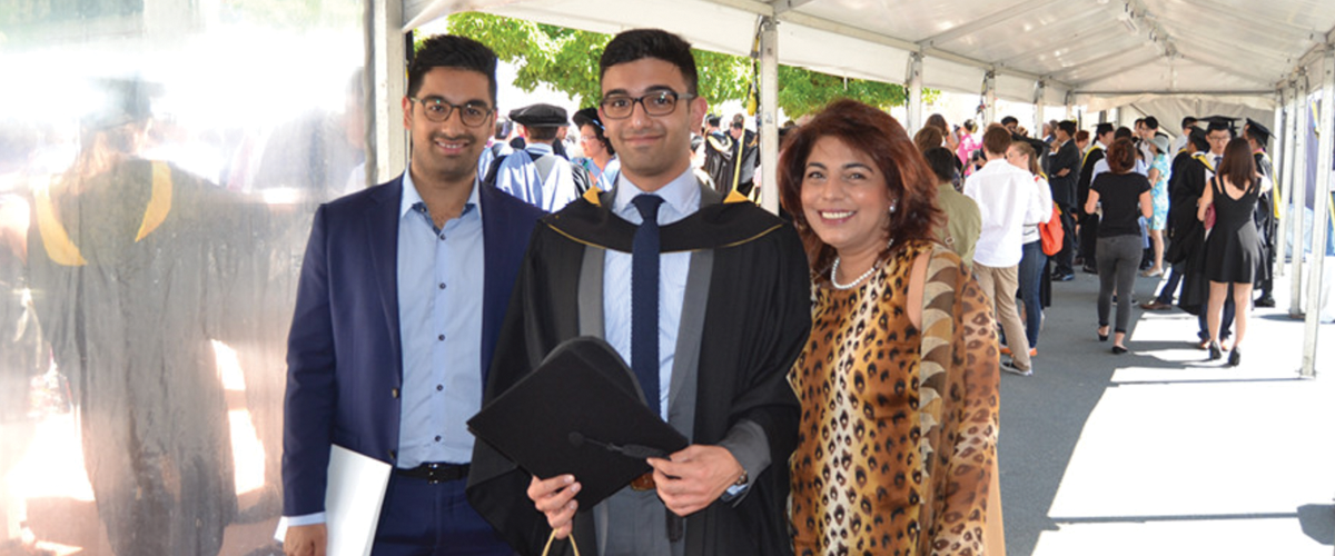 A graduating student poses with his family at Australian National University