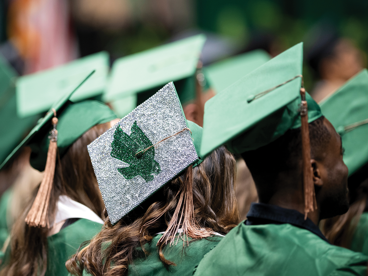 Students in green caps and gowns