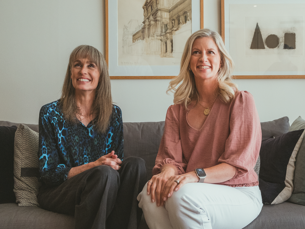 Joanna Logan and Erin Hall-Westfall posing on a couch