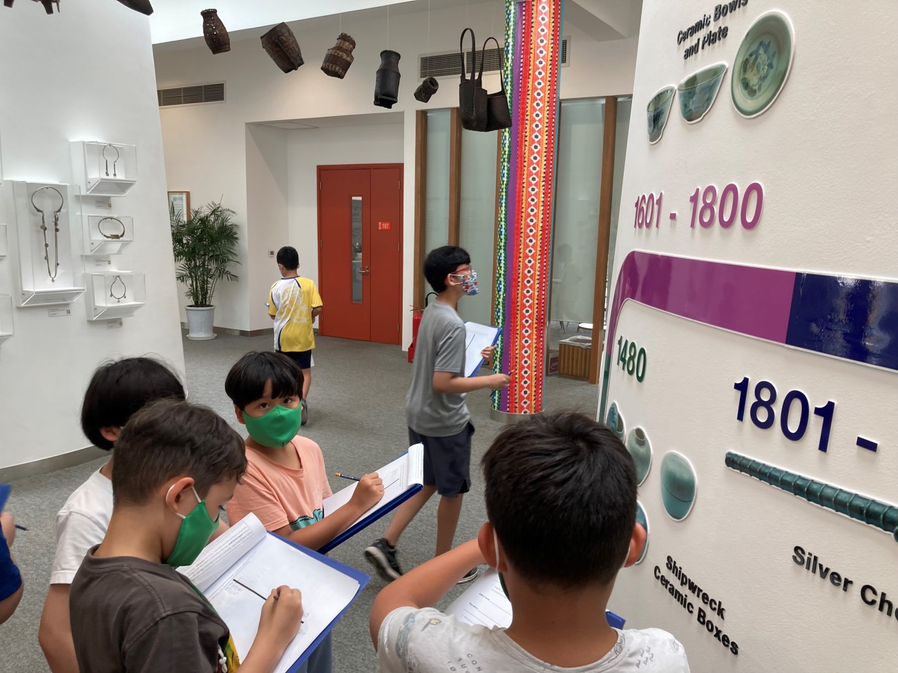 students exploring the UNIS Hanoi cultural collection and filling out a worksheet