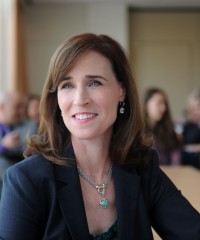 Image of Christine Riordan with people in the background, blurred