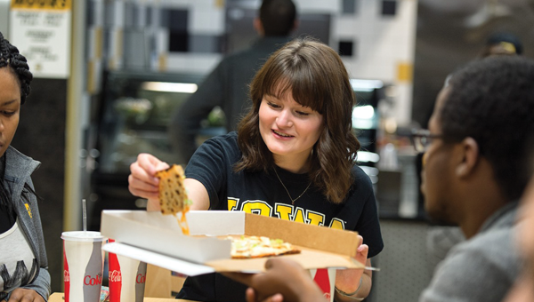Students eat pizza at the University of Iowa Center for Advancement