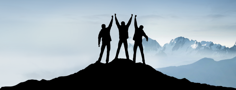 group in silhouette on mountain top