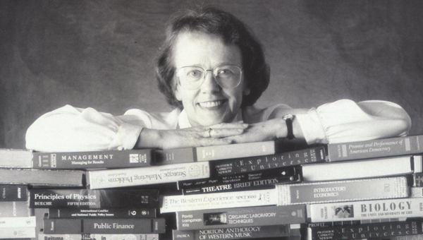 Founding Editor Virginia Carter Smith poses with stacks of books.
