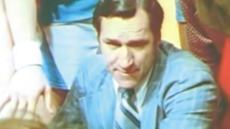 Coach Smith crouches in the middle of huddle during a timeout in the 1974 UNC/Duke basketball game.