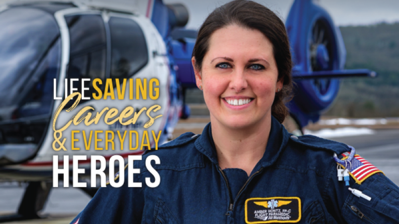 The cover of BROOME alumni magazine's spring 2024 issue shows a flight paramedic smiling for camera. She holds her flight helmet under one arm and a helicopter can be seen on a landing pad in the background.