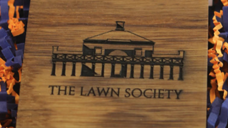 A block of wood engraved with the image of a UVA campus building and the words, "The Lawn Society."