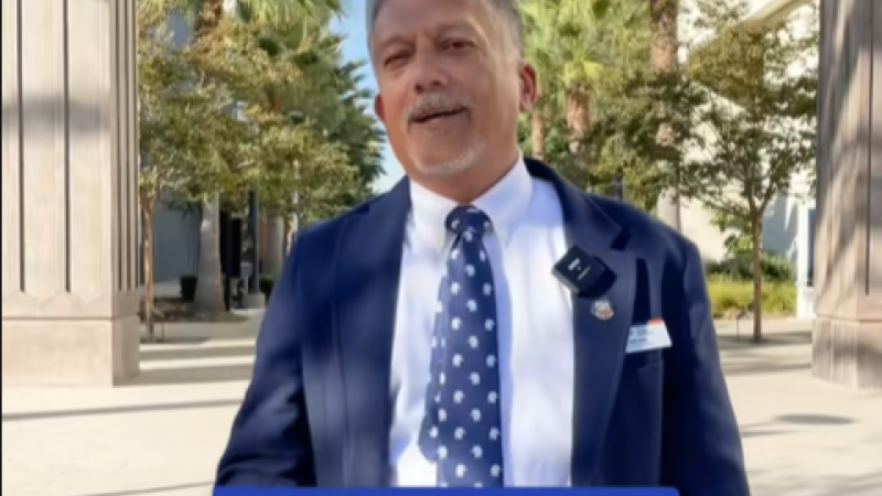 A screenshot from Fullerton's Gen Z TikTok video. A Fullerton staff member stands on campus and the caption reads "Gain 1,000 aura points."