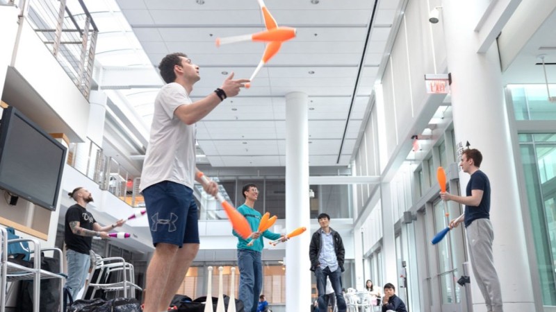 The Cornell Juggling Club practices in the atrium of a campus building.