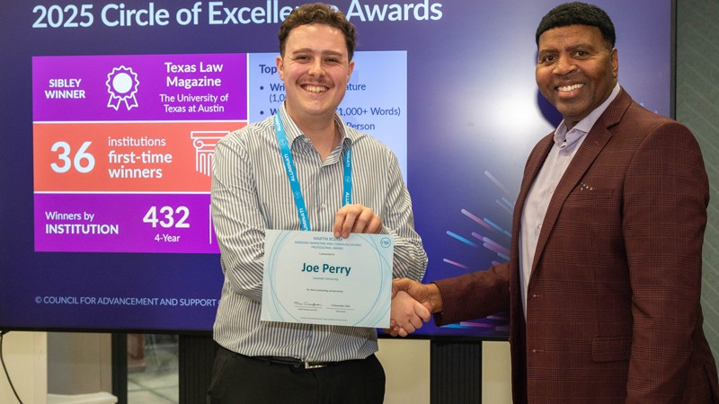Joe Perry, award winner, shaking the hand of CASE VP, Rob Henry