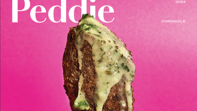 In front of the Peddie Chronicle masthead, is the photo of a piece of breaded chicken dripping in a yellow sauce with herbs in it against a pink background.