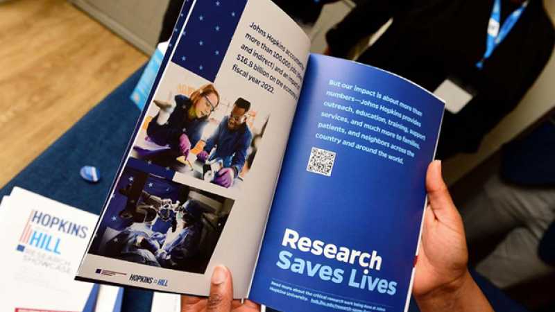 A photo of someone holding open a Research Saves Lives campaign booklet.