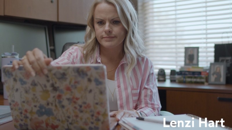 A woman sits in an office, about to close a laptop with a flora cover. The caption reads, "Lenzi Hart, Texas Tech K-12 Teacher."