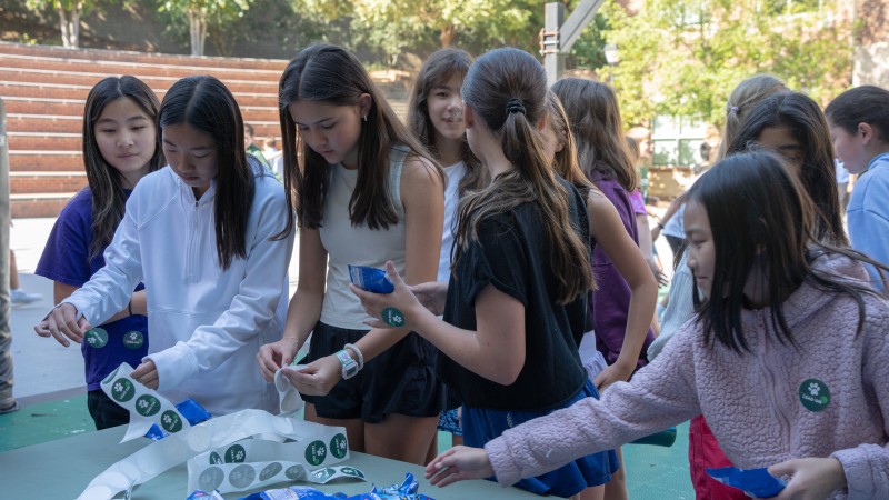 Students from The Westminster Schools crowd around a table to get stickers and Oreos.