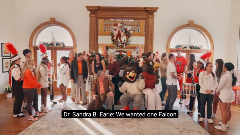 Members of BGSU's marching band, sports teams, and more gather with the university's mascots and president for a holiday photo.