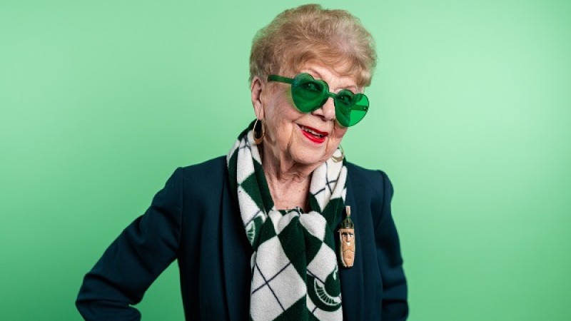 A photo of Jan Alleman wearing green heart-shaped sunglasses.