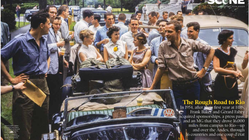 A photograph from 1954. Two men stand on either side of a car full of travel supplies.