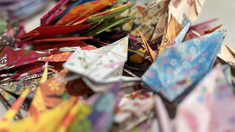A pile of origami cranes, all made from different patterned paper.