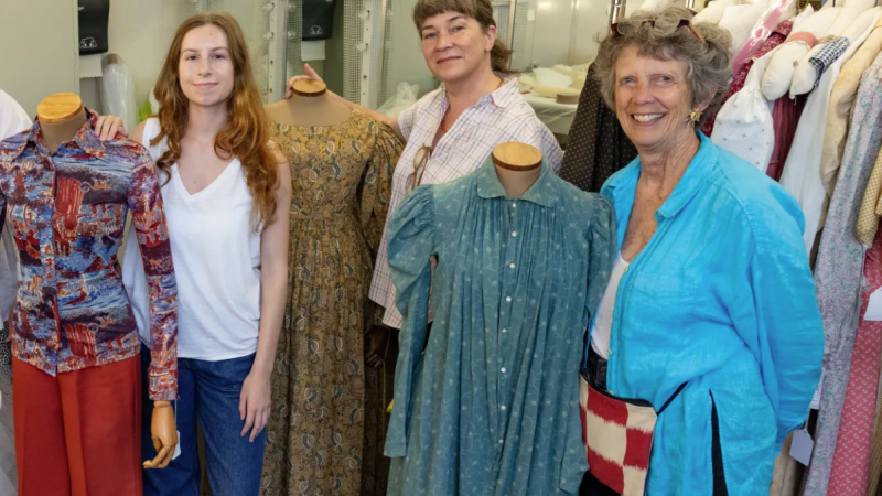 Virginia Cornett ’27, Rebecca Shea ’99, and Kiki Smith ’71, pose amongst busts dressed in women's clothes from Smith College's Historic Clothing Collection. 